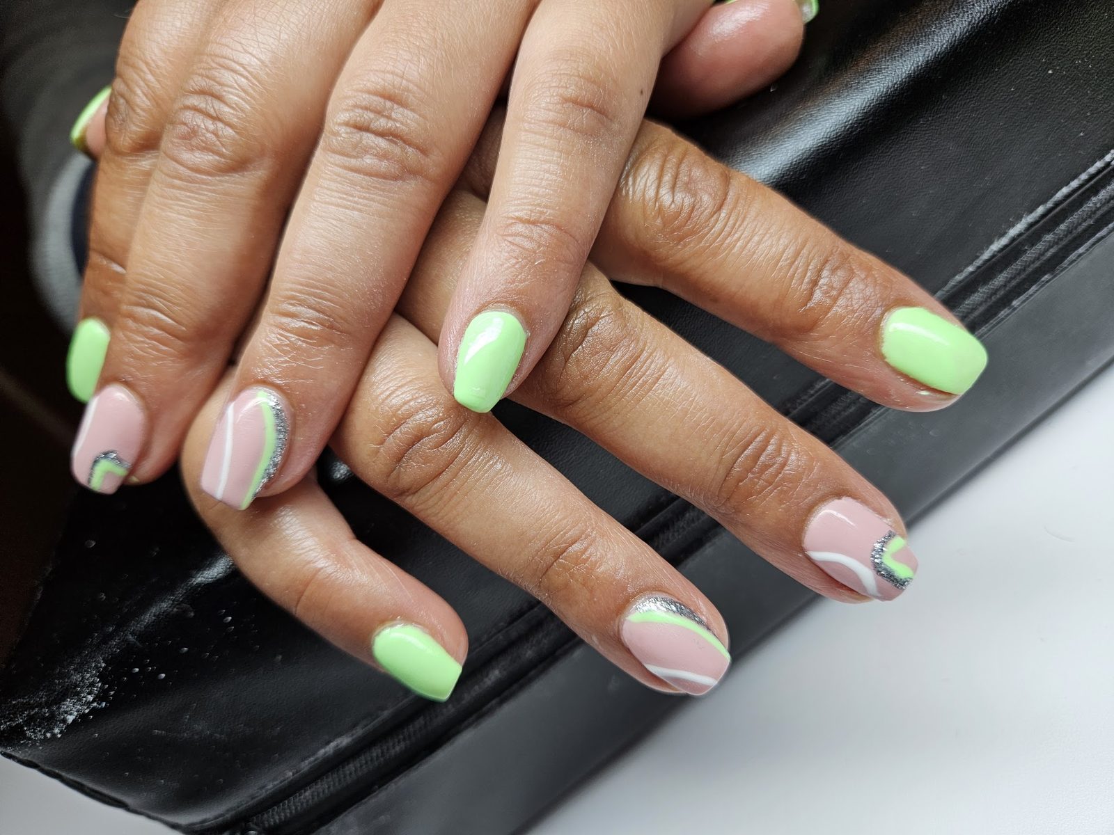 Mintgroene nagels met nude en een swirl als nail-art