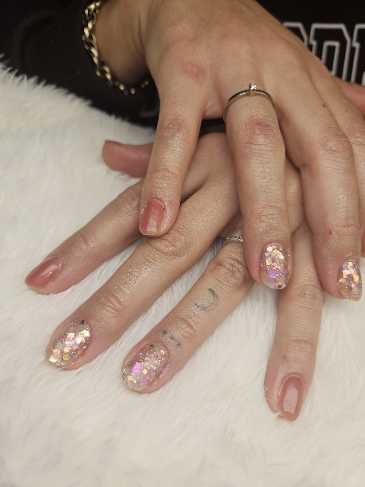 Naturelle nagels met grove glittervlokken op een witte vacht