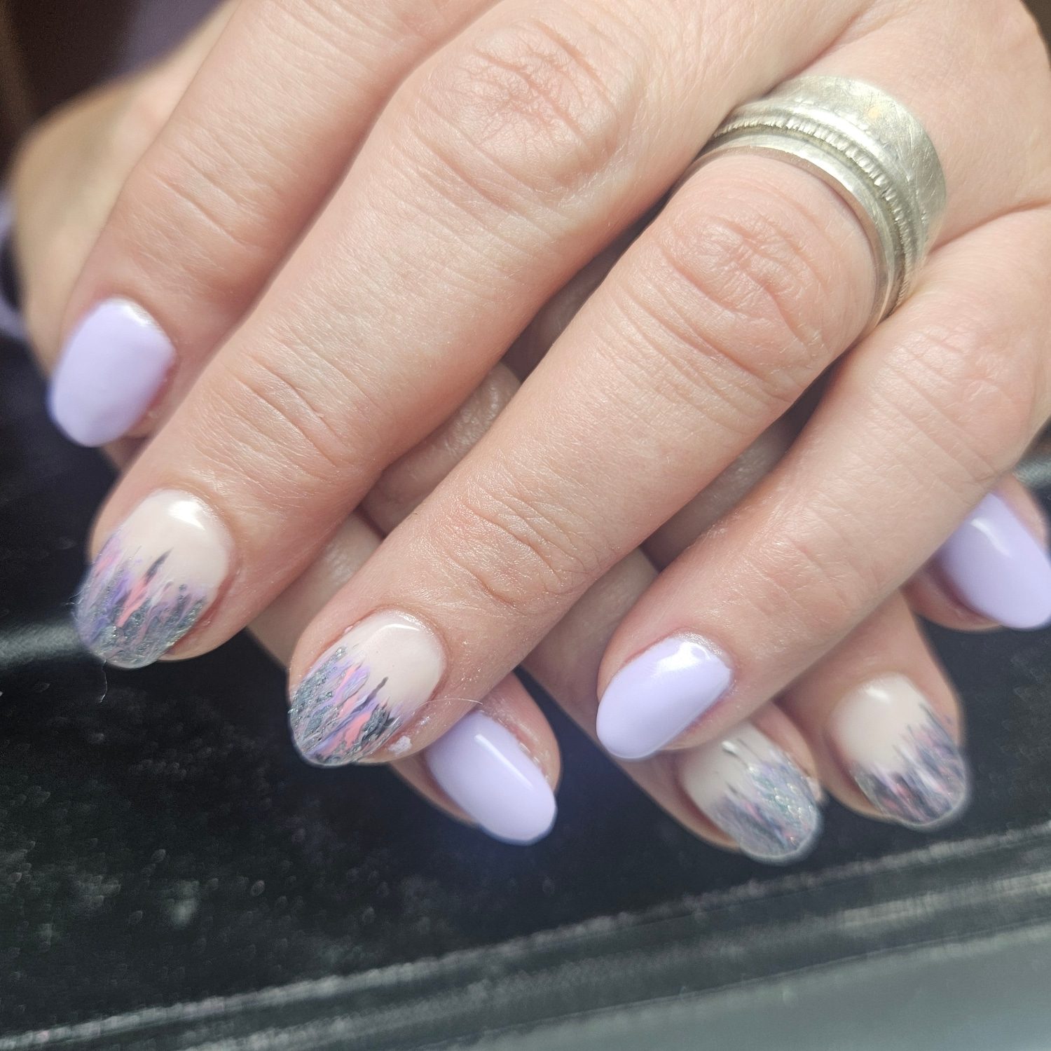 Lila nagels met grijze en zilveren veertjes als nail-art